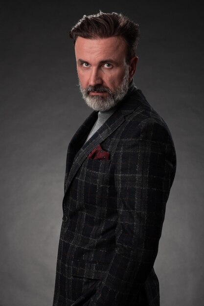 Porträt eines stilvollen, eleganten Senior-Geschäftsmanns mit Bart und legerer Business-Kleidung in Fotos s