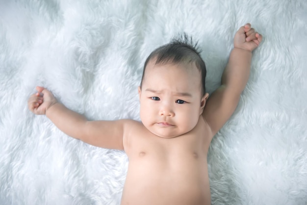 Porträt eines süßen asiatischen Babys in rosafarbenem Kleid auf Teppichwolleglückliche Babykonzeptemilethail kleines Baby