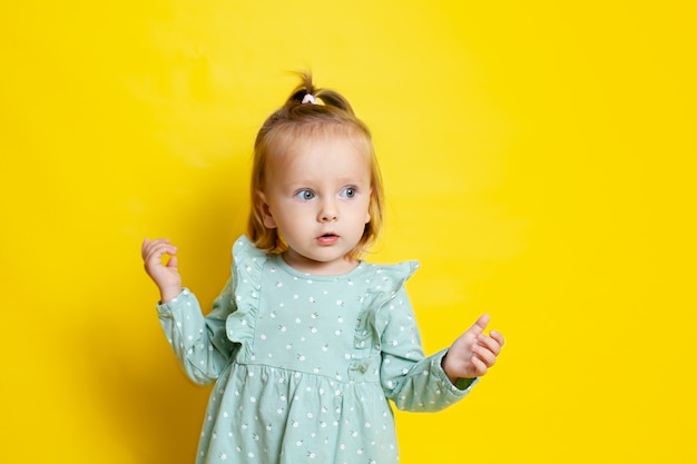 Porträt eines süßen Babys mit blauen Augen auf gelbem Hintergrund. Ein Platz für Texte. Foto in hoher Qualität