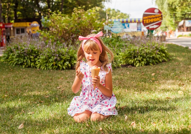 Porträt eines süßen blonden kleinen Mädchens mit Eis auf einem Spaziergang im Park.