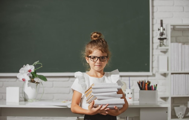 Porträt eines süßen, hübschen Mädchens in Schuluniform im Klassenzimmer Nerd-Schulmädchen in Brille mit Büchern o