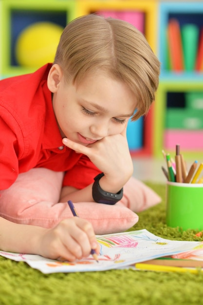 Porträt eines süßen Jungen, der mit Bleistiften zeichnet