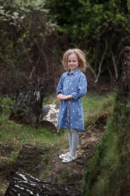 Porträt eines süßen kaukasischen Mädchens von 5 Jahren, das im Wald steht und in die Kamera schaut