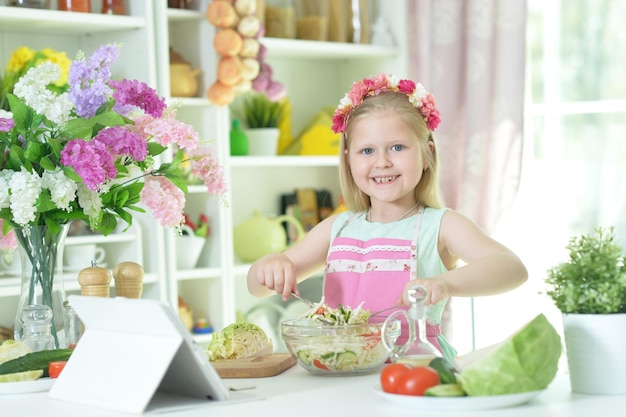 Porträt eines süßen kleinen Mädchens, das Abendessen zubereitet