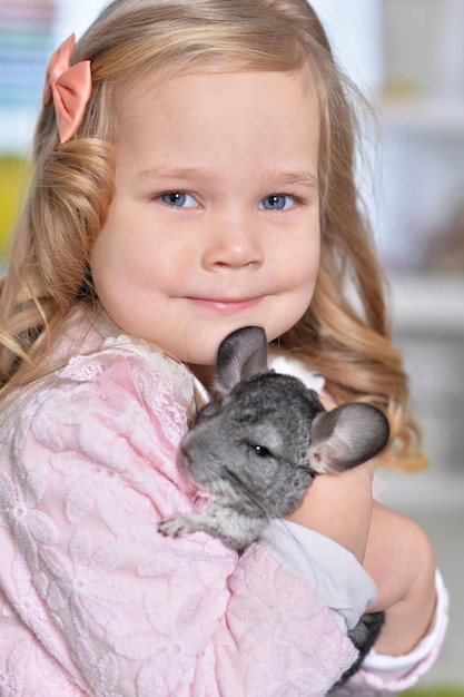 Porträt eines süßen kleinen Mädchens, das mit Chinchilla spielt