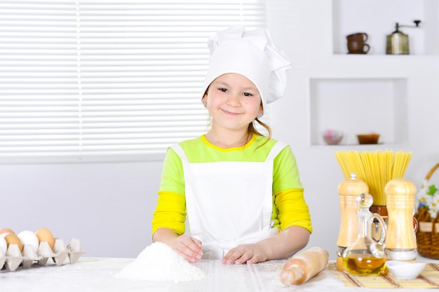 Porträt eines süßen Mädchens, das Kuchen in der Küche backt