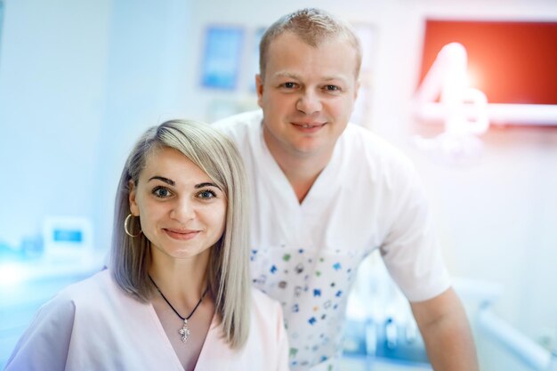 Porträt eines Teams von Ärzten, Mann und Frau, die Uniform auf dem Hintergrund der Zahnarztpraxis tragen Stomatologie-Konzept