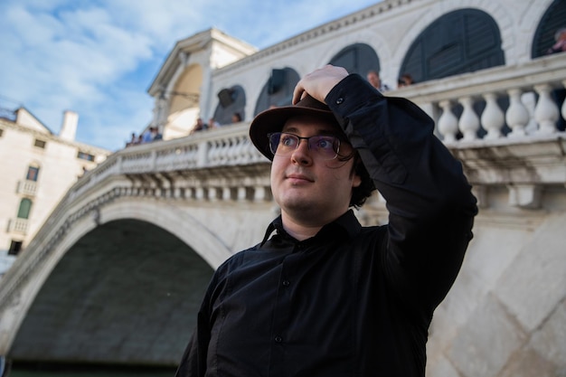 Porträt eines Touristen in Venedig vor der Rialtobrücke mit Blick auf das seitliche Foto mit Copyspace auf der linken Seite