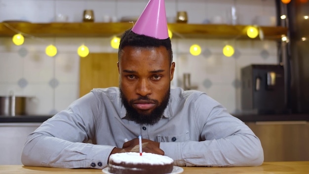 Porträt eines traurigen, einsamen jungen afroamerikanischen Mannes, der allein seinen Geburtstag feiert