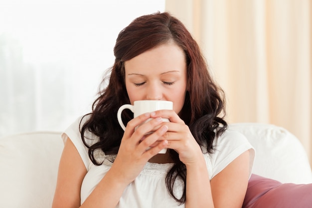 Porträt eines trinkenden Kaffees der herrlichen Frau