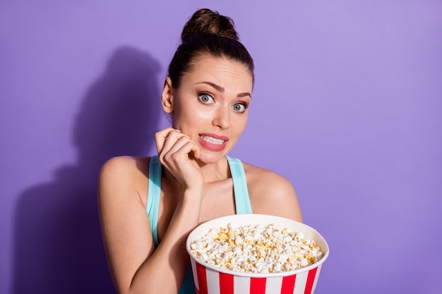 Porträt eines verängstigten Mädchens, das Mais isst und Thriller-Genrefilm anschaut