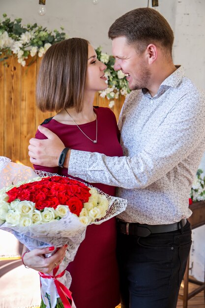 Porträt eines verliebten Paares mit einem großen Rosenstrauß