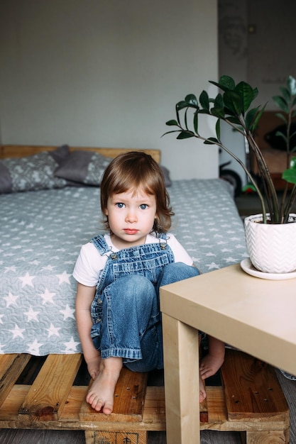 Porträt eines Vorschulkindes zu Hause, das ernsthaft in die Kamera blickt