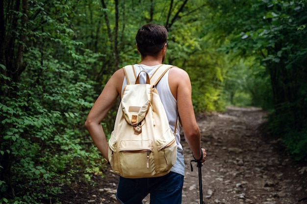 Porträt eines Wanderers, der auf dem Weg im Wald spazieren geht