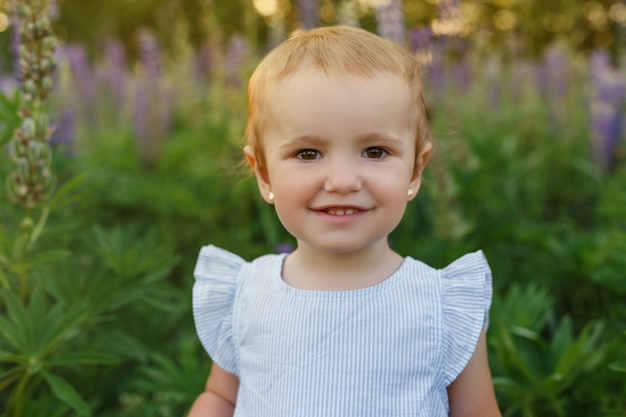 Porträt einjähriges Mädchen im Kleid. Kinder spielen im Freien