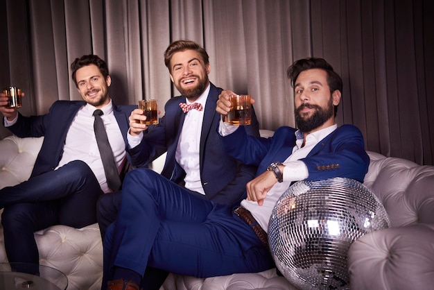 Foto porträt eleganter männer mit whisky im nachtclub