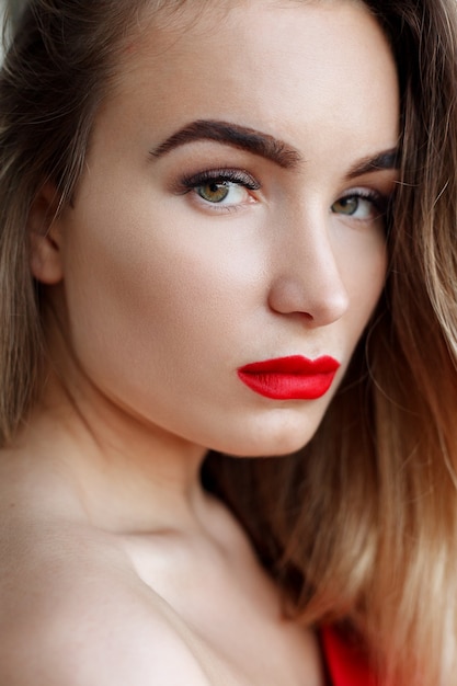 Porträt, Emotionen, Menschen, Schönheitskonzept - Modekunststudio-Porträtfrau mit roten Lippen. Modischer Lippenstift. Professionelle Kosmetik. Porträt der Schönheit im schwarzen Kleid mit großen sexy Lippen.