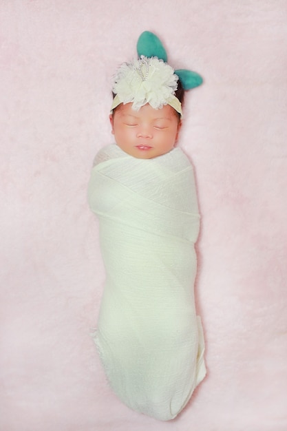 Porträt entzückend des kleinen asiatischen Neugeborenenbabys, das auf flauschigem weichem Bett schläft
