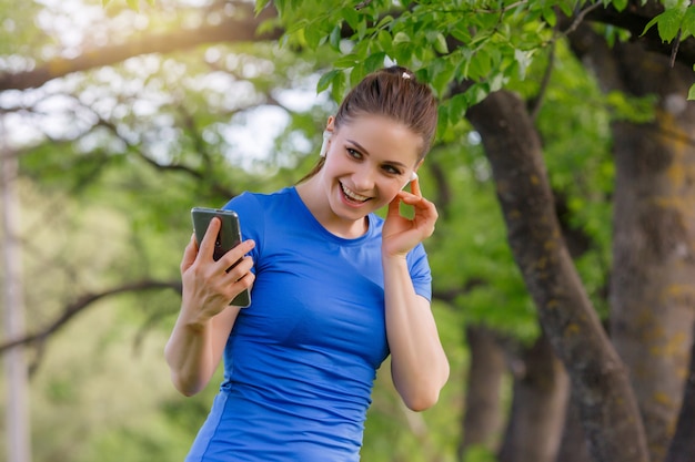 Porträt Frau Training im Park und Musik hören