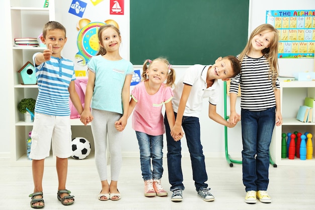 Porträt glücklicher Klassenkameraden, die im Klassenzimmer in die Kamera schauen