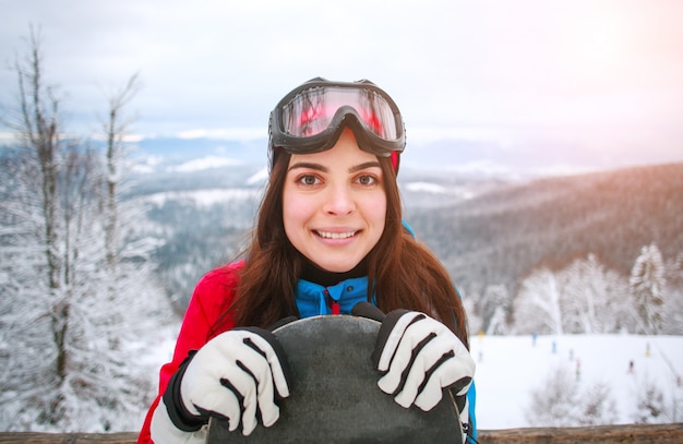 Porträt glückliches womanwith Snowboard auf schneebedeckten Berg