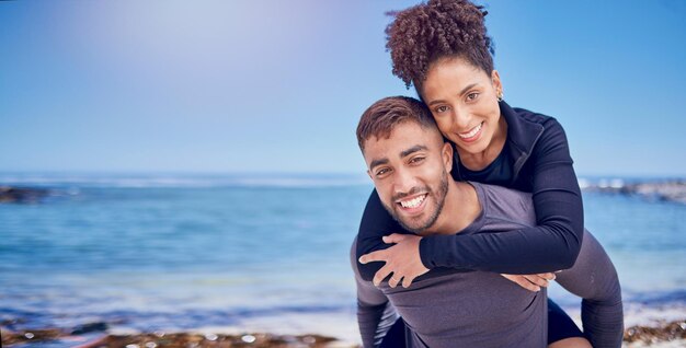 Porträt Huckepack und Strand mit Paarliebe und Abenteuer mit Fitnessreisen und Mock-up-Raum Gesicht Menschen und Mann tragende Frau mit Bindung am Meer oder Liebe zusammen mit Sommerurlaub