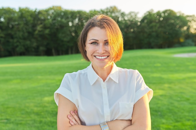 Porträt im Freien der positiven überzeugten reifen Frau