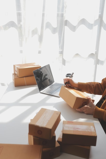 Foto porträt junge attraktive hipster asien besitzerin startup blick auf kameraarbeit glücklich mit box zu hause bereiten paketzustellung in sme lieferkettenbeschaffung omnichannel ecommerce online konzept vor