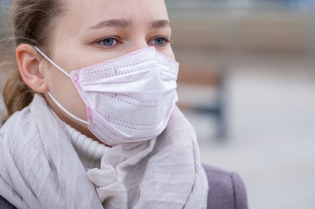 Porträt junge europäische Frau in der medizinischen Einwegmaske des Schutzes in verlassener Stadtstraße im Freien. Konzept der Coronavirus Influenza Covid-19 Quarantäne und Menschen Panik