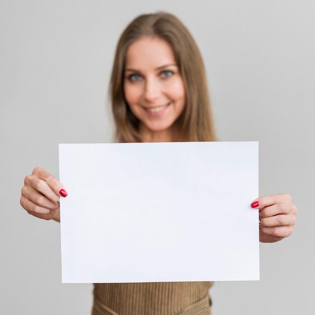 Foto porträt junge frau, die papierblatt hält