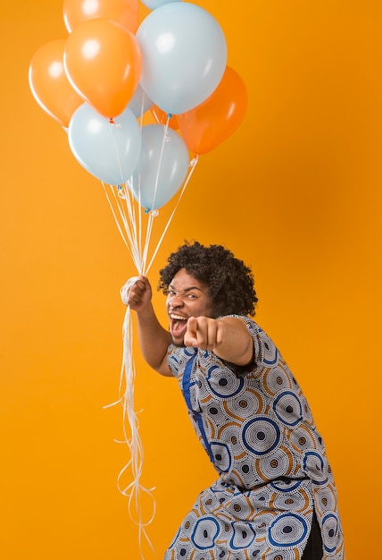 Foto porträt junger mann auf party mit luftballons