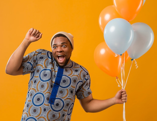 Foto porträt junger mann auf party mit luftballons