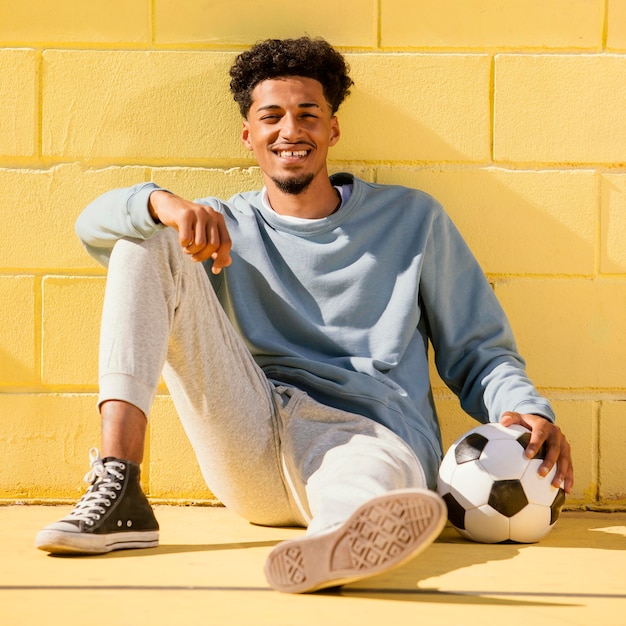 Foto porträt junger mann mit fußball