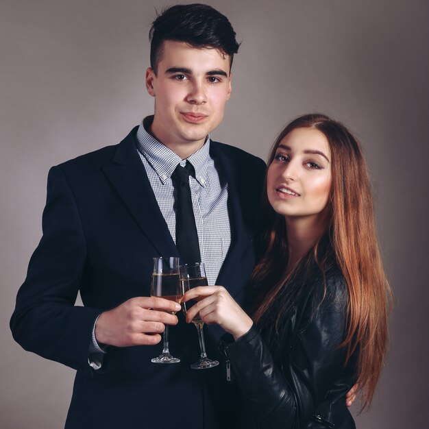 Porträt junges Paar mit Glas Champagner, Abendkleid und Anzug tragen, Glamour-Mode-Stil