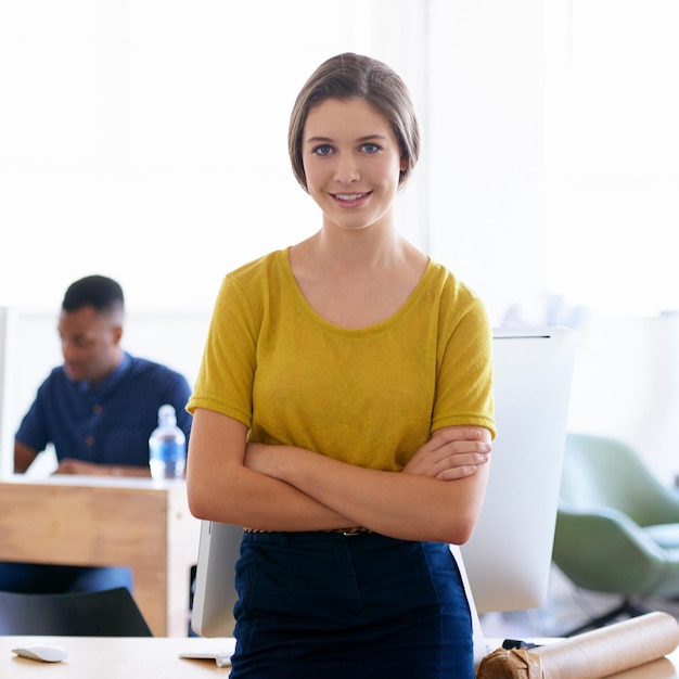 Porträt Lächeln und Geschäftsfrau mit gekreuzten Armen am Arbeitsplatz Büro oder Start-up-Unternehmen für den Job des Mitarbeiters Gesicht Selbstvertrauen und glücklicher Unternehmer oder kreativer Designer Coworking für die Karriere