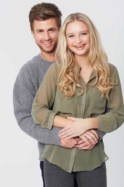 Porträt Lächeln und Paar zusammen Liebe oder Pflege in einer gesunden Beziehung isoliert auf einem weißen Studio-Hintergrund Glücklicher Mann Frau oder Partner umarmen sich in Verbindung Unterstützung oder lustiges Lachen für Bindung