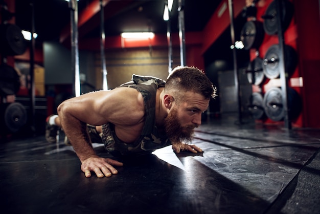 Porträt Nahaufnahme des stark motivierten muskulösen bärtigen Bodybuilder-Mannes mit kurzen Haaren