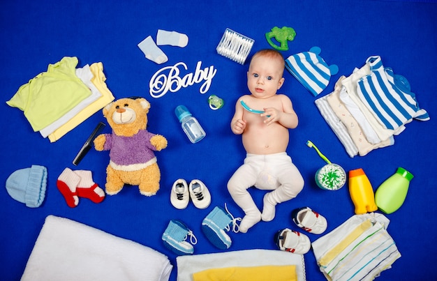 Porträt niedlicher kleiner Junge mit den blauen Augen, die auf Bett liegen