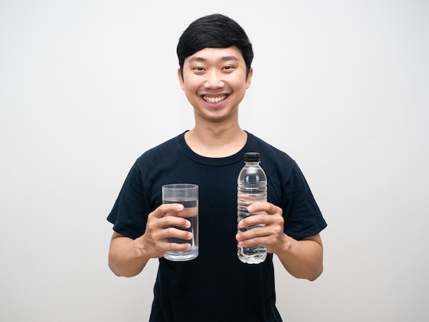 Porträt positiver Mann hält Glas mit Wasserflasche glückliches Lächeln weißen Hintergrund
