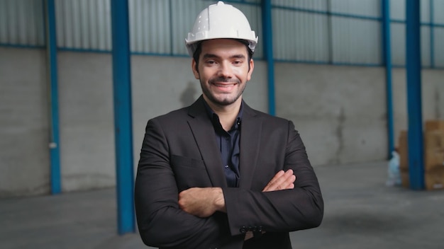 Porträt selbstbewusster Fabrikleiter mit Anzug und Schutzhelm in der Fabrik. Industrie- und Engineering-Konzept.