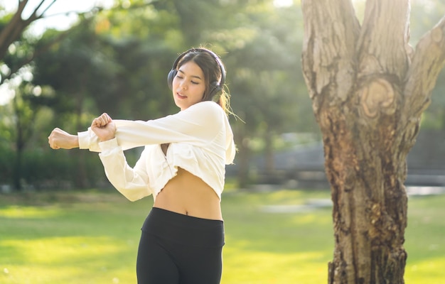 Porträt Sport asiatische Schönheit Körper schlanke Frau beim Aufwärmen in Sportkleidung entspannen und Fitnessübungen mit Stretching-Training vor dem Fitnesstraining im Park machenDiätkonzeptFitness und gesund