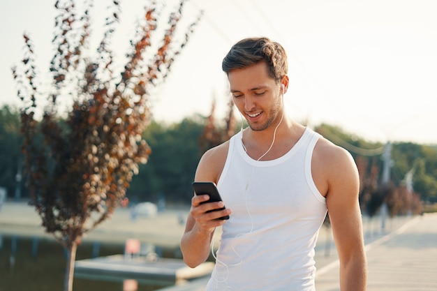 Porträt sportlicher Mann mit Handy