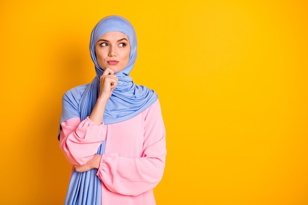 Porträt von attraktiven, intelligenten, klugen Muslimen, die Hijab-Denken tragen, isoliert auf hellgelbem Hintergrund