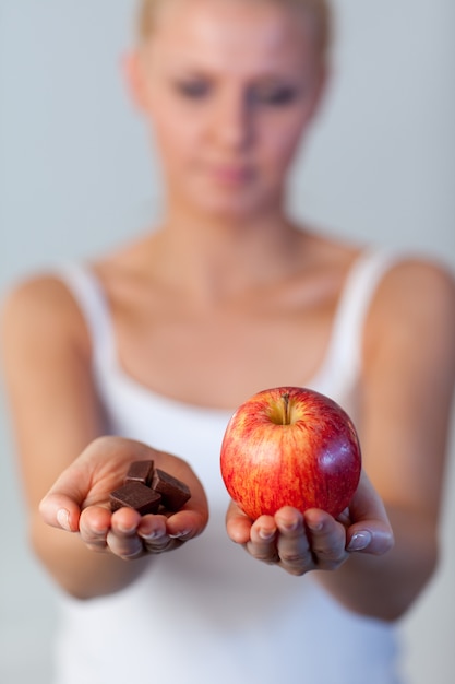 Porträt von awoman Schokoladen- und Apfelfokus halten auf Apfel