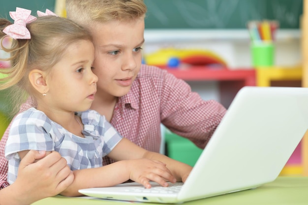 Porträt von Bruder und Schwester mit Laptop