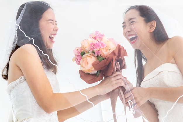 Porträt von den asiatischen homosexuellen Paaren, die Blume im Brautkleid halten Konzept-LGBT-Lesbe.