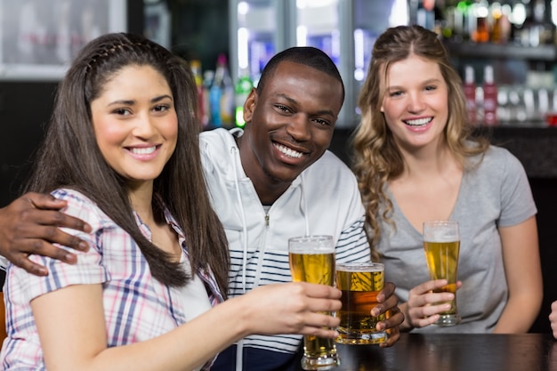 Porträt von den glücklichen Freunden, die etwas trinken