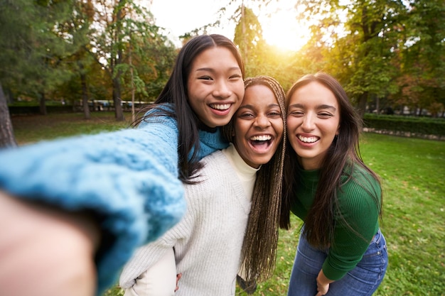 Porträt von drei Mädchen im Freien, die Selfie machen, Freundschaft in multiethnischen Gruppen, multiracialen Menschen