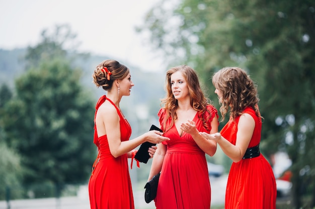 Porträt von drei schönen brautjungfern im roten kleid