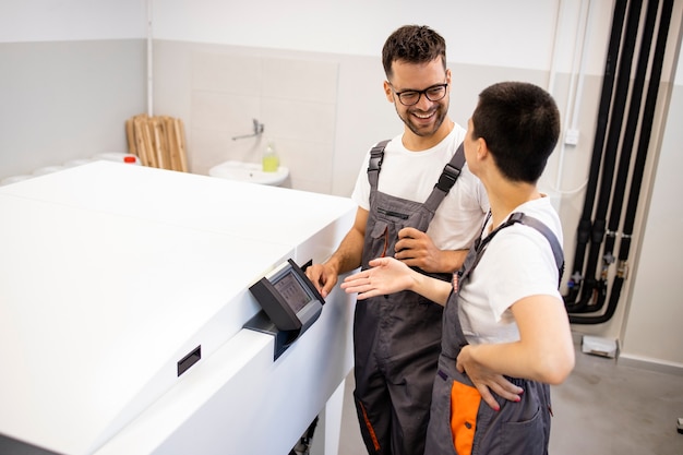 Porträt von Druckarbeitern, die in der Druckerei vom Computer zur Plattenmaschine stehen.